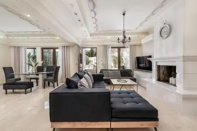 a living room with a black couch and a fireplace at Mikaela's Pool House in Afantou