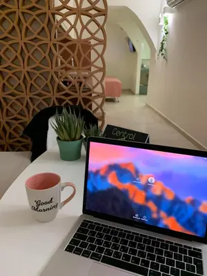 a laptop computer sitting on a table with a cup of coffee at Central Grinn-in the heart of Rhodes,new&stylish! in Rhodes Town