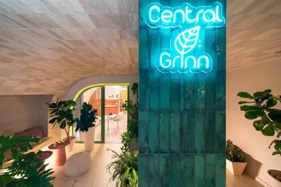 a sign on a column in a room with plants at Central Grinn-in the heart of Rhodes,new&stylish! in Rhodes Town