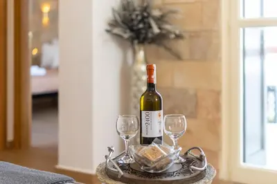 a bottle of wine and two glasses on a table at Medieval Poem in Rhodes Town