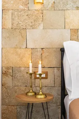 two candles on a table in front of a brick wall at Medieval Poem in Rhodes Town