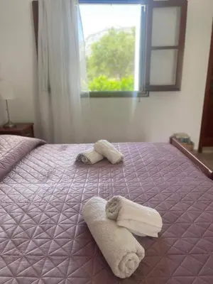 a bed with two towels on it with a window at Aegean Endless Summer Villa Pefkos in Pefki Rhodes