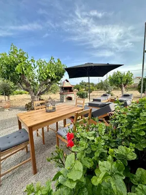 a wooden table with an umbrella and some plants at Aegean Endless Summer Villa Pefkos in Pefki Rhodes