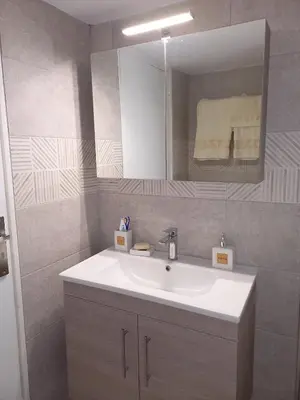 a bathroom with a white sink and a mirror at Andreas Apartment in Rhodes Town