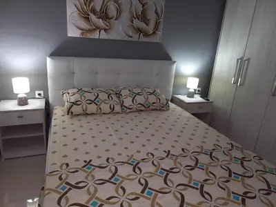 a bedroom with a large bed with two night stands at Andreas Apartment in Rhodes Town