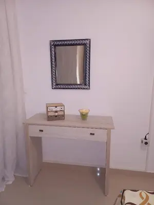 a dressing table with a mirror on a wall at Andreas Apartment in Rhodes Town