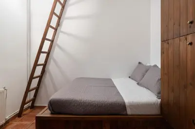 a bedroom with a bed and a wooden ladder at Pure Nature Cottage in Láerma