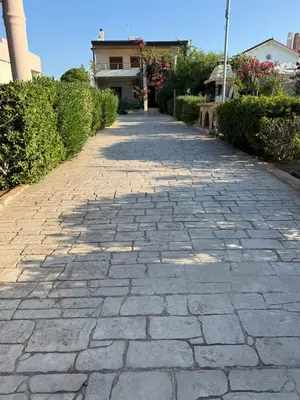 a cobblestone pathway in front of a house at Amaryllis front beach hotel in Lardos