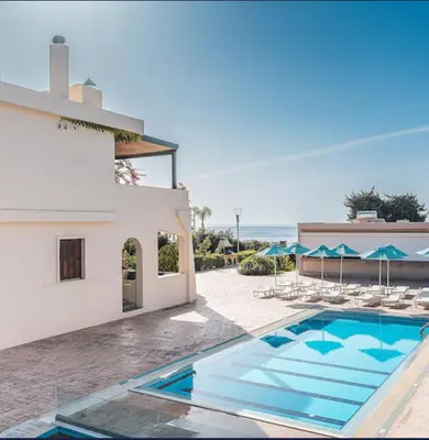 a villa with a swimming pool next to a building at Amaryllis front beach hotel in Lardos
