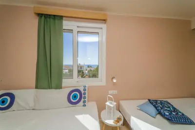 a bedroom with two beds and a window at Amaryllis front beach hotel in Lardos