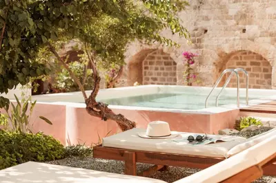 a hot tub in a garden with a hat on a table at Saray Monumental Luxury Villa Medieval Town, Rhodes in Rhodes Town