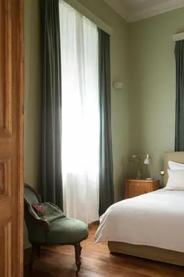 a bedroom with a bed and a chair and a window at Saray Monumental Luxury Villa Medieval Town, Rhodes in Rhodes Town