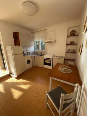 a small kitchen with a table and a refrigerator at Plastiras Sea View Apartments in Archangelos