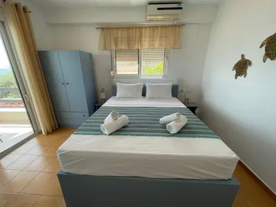 a bedroom with two beds with towels on them at Plastiras Sea View Apartments in Archangelos