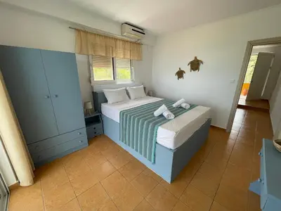 a small bedroom with a bed and a window at Plastiras Sea View Apartments in Archangelos