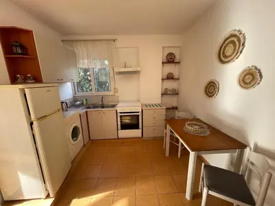 a small kitchen with a table and a refrigerator at Plastiras Sea View Apartments in Archangelos