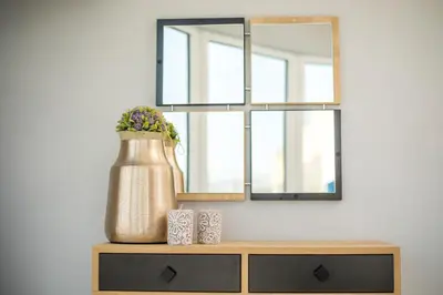 a mirror on top of a dresser with a vase at Haraki Blue Dream Luxury Apartments in Haraki