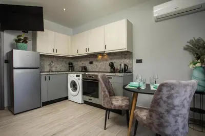 a kitchen with a table and a dishwasher at Haraki Blue Dream Luxury Apartments in Haraki
