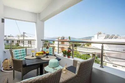 a balcony with a table and chairs with a view at Haraki Blue Dream Luxury Apartments in Haraki