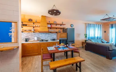 a kitchen and living room with a table and a couch at Olympia Villa in Gennadi