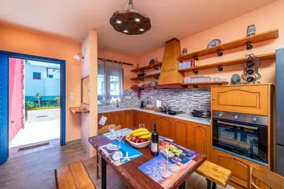 a kitchen with a table with a bowl of fruit on it at Olympia Villa in Gennadi