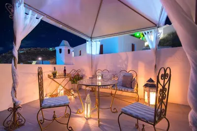 a table and chairs on a patio at night at Lindos Harmony Suites in Líndos
