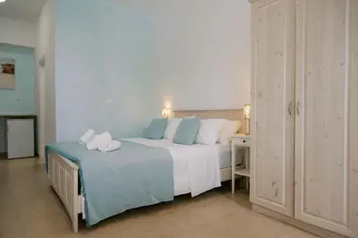 a bedroom with a bed with towels on it at Lindos Harmony Suites in Líndos