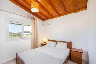 a bedroom with a bed and a window at Platanos House in Faliraki