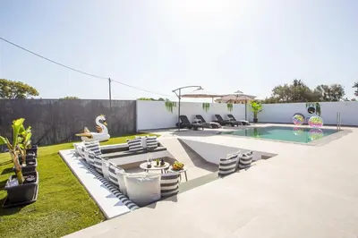 a backyard with a pool and chairs and a swimming pool at Platanos House in Faliraki