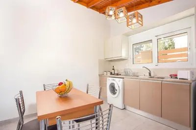 a kitchen with a table and a washing machine at Platanos House in Faliraki