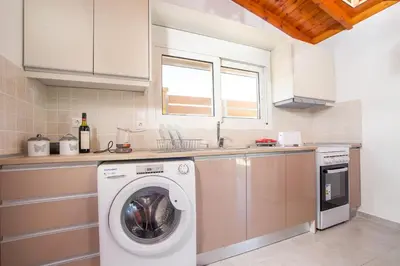 a kitchen with a washing machine and a sink at Platanos House in Faliraki