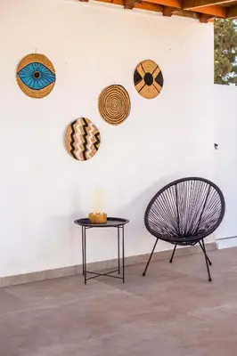 a chair and a table in front of a wall at Platanos House in Faliraki