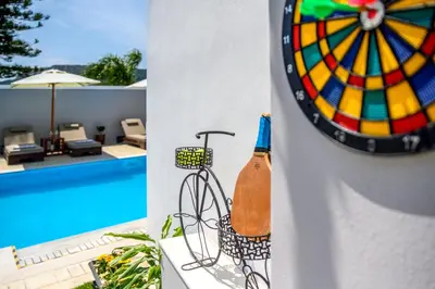 a bottle of wine on a wall next to a pool at Pervolia House Private Villa Near Airport in Kremasti