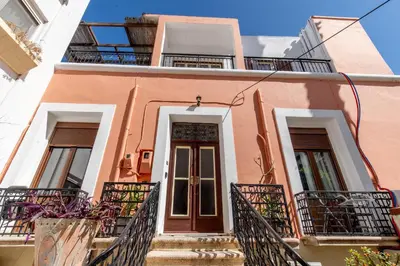 a pink building with stairs and balconies at mascot traditional guest house in Rhodes Town