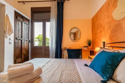 a bedroom with a large bed and a window at mascot traditional guest house in Rhodes Town