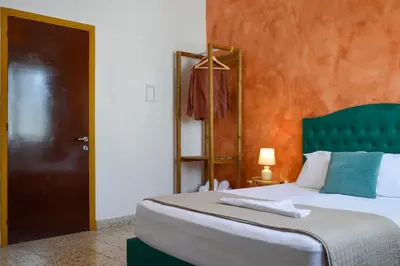 a bedroom with a large bed with a green headboard at mascot traditional guest house in Rhodes Town