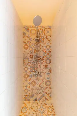 a shower in a bathroom with a tile wall at mascot traditional guest house in Rhodes Town