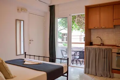 a bedroom with a bed and a kitchen with a balcony at mascot traditional guest house in Rhodes Town