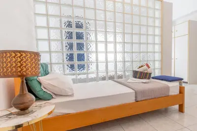 a bedroom with a bed and a large window at mascot traditional guest house in Rhodes Town
