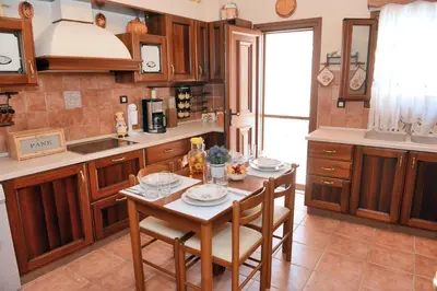 a kitchen with a table and chairs in a kitchen at Classical Villa Archontiko D&M in Rhodes Town