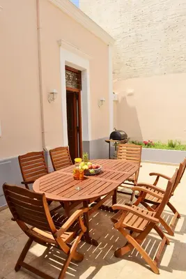 a wooden table with chairs and a table with fruit on it at Classical Villa Archontiko D&M in Rhodes Town