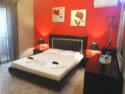 a bedroom with red walls and a bed with towels on it at EnjoyRhodes Villa near Faliraki in Kalithies