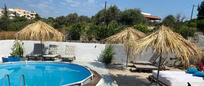 a pool with chairs and umbrellas in a yard at EnjoyRhodes Villa near Faliraki in Kalithies