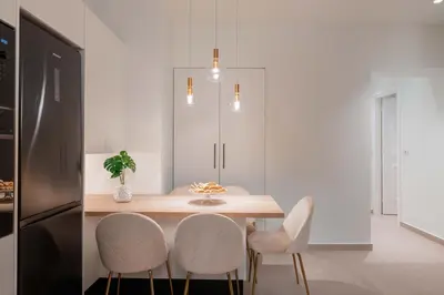 a dining room with a table and four chairs at Mariann Premium Suites in Lardos