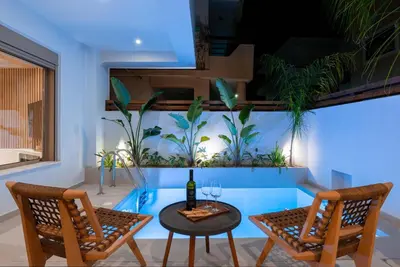 a room with a table and chairs and an aquarium at Mariann Premium Suites in Lardos