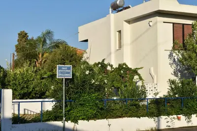 a blue and white sign in front of a building at Pervoli in Faliraki