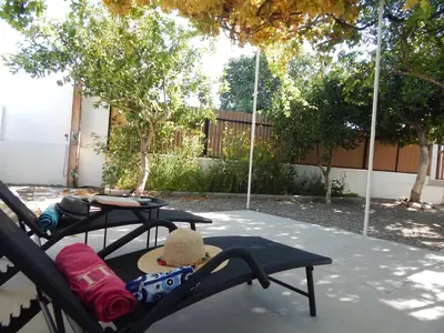 a patio with two chairs and a table with a hat at Pervoli in Faliraki