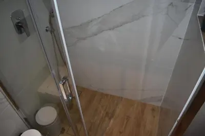 a shower with a glass door and a toilet at Pervoli in Faliraki