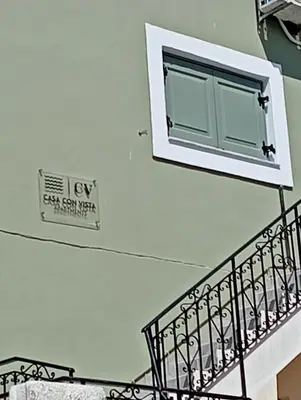 a window on the side of a wall next to a staircase at Casa Con Vista Apartments in Halki