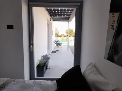 a bedroom with a door leading to a patio at Casa di Rea Sanfilippo in Soroni